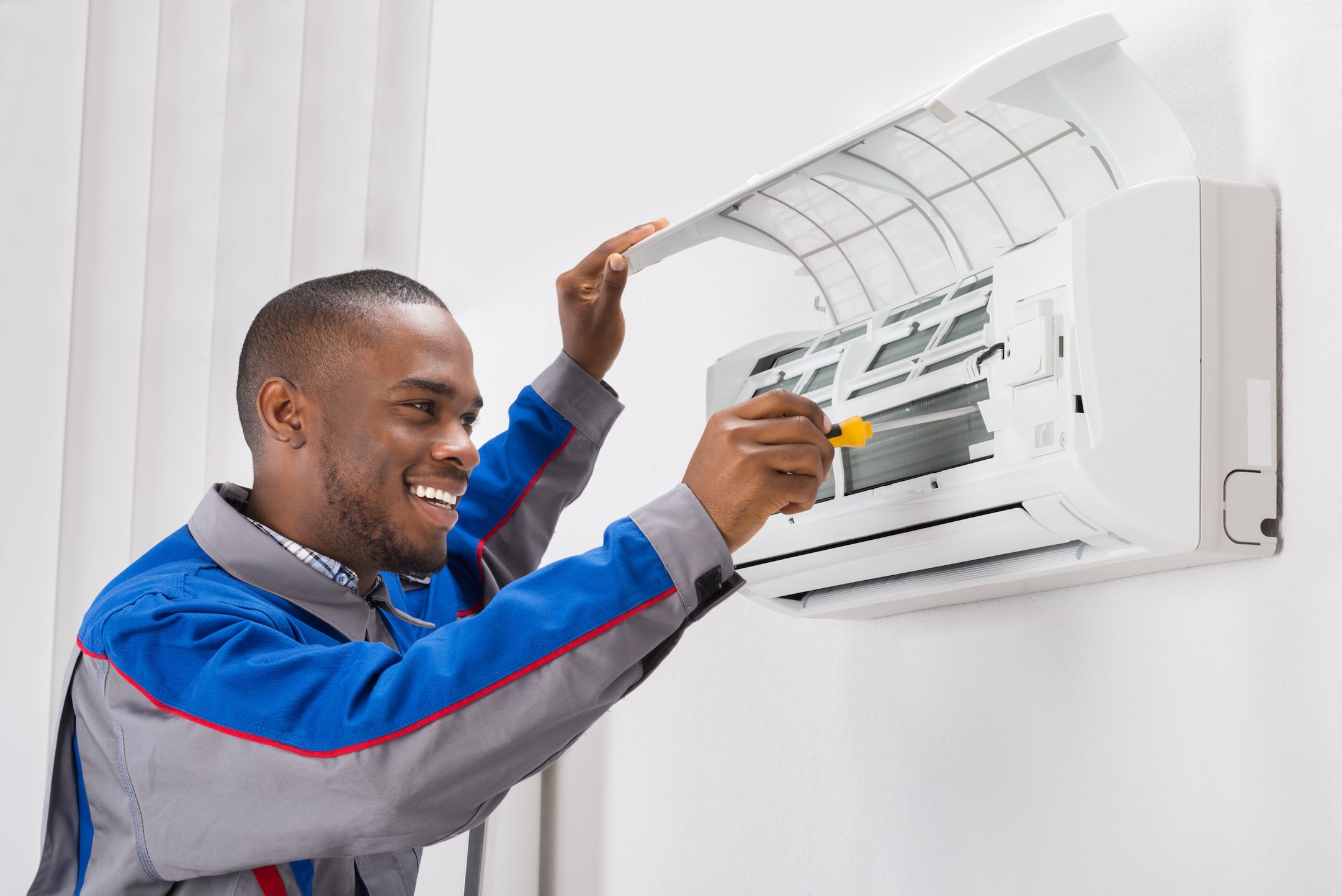 HVAC technician performing preventive air conditioner maintenance in St. Louis, MO