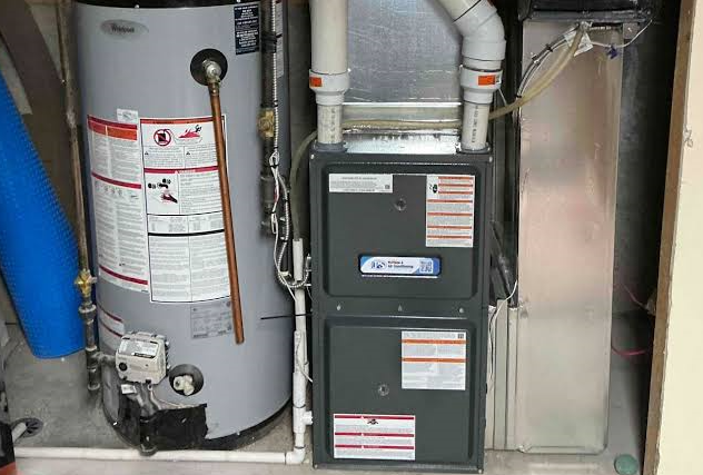 HVAC technician installing a new high efficiency gas furnace in St. Louis, MO